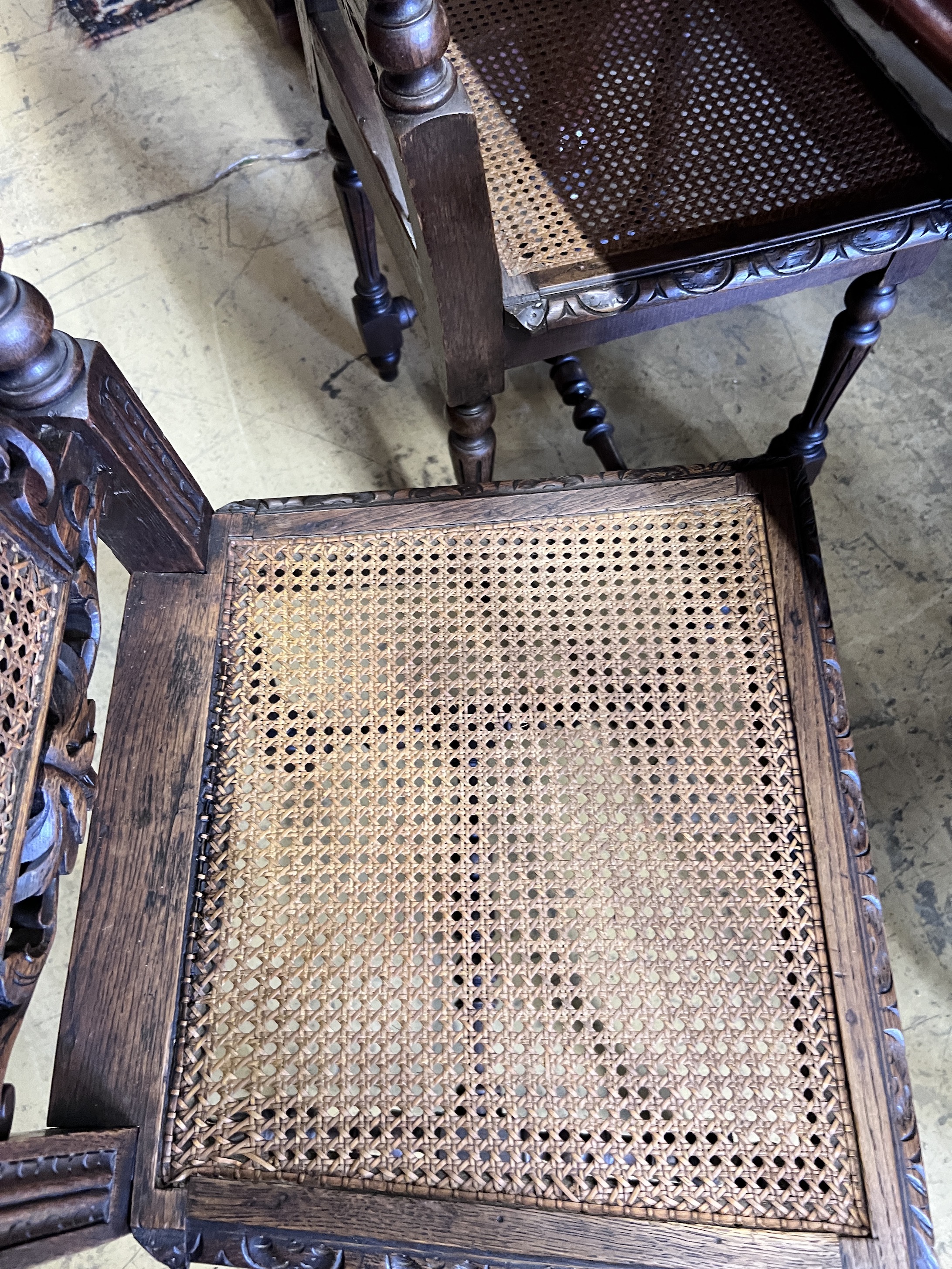 A set of four late 19th century Flemish style carved oak dining chairs with caned seats